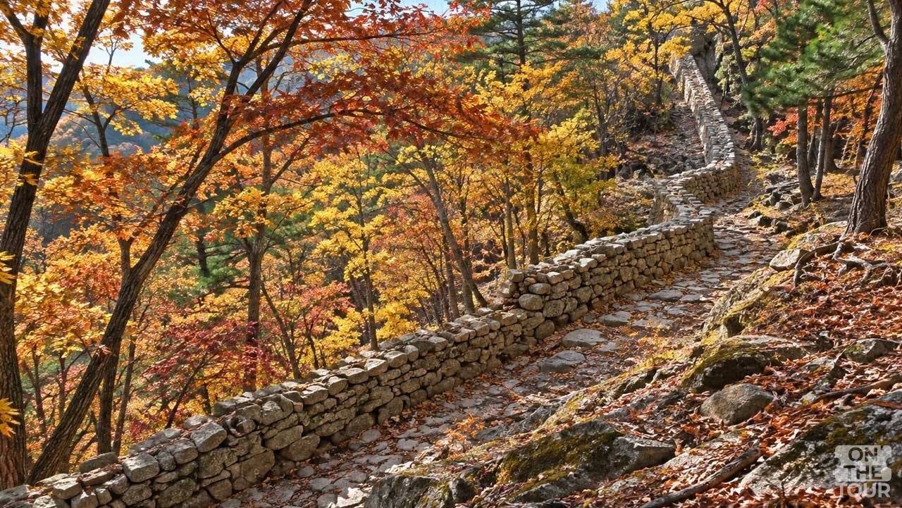단풍 숲 사이로 돌담과 돌길이 이어지는 인제 한계산성의 가을 풍경. (AI 생성) / 온더투어