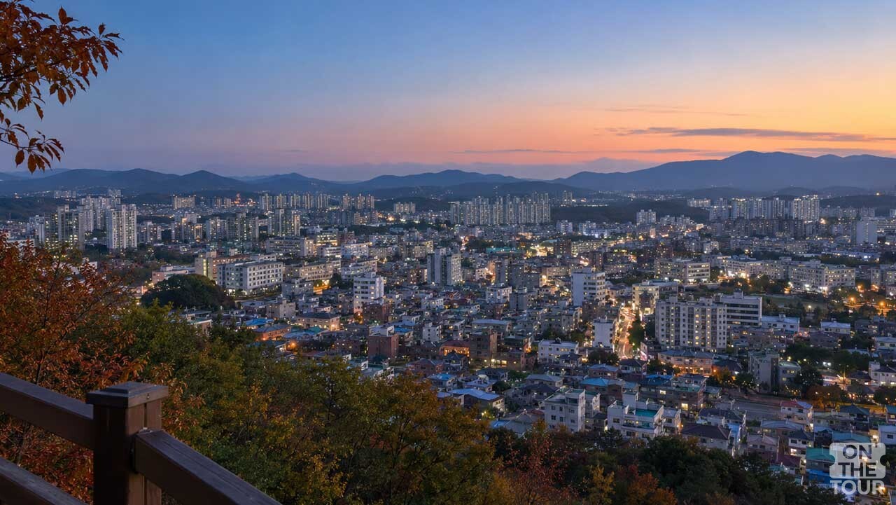 노을이 남은 하늘 아래 도심의 불빛이 켜지는 청주 수암골 전망대 풍경. (AI 생성) / 온더투어