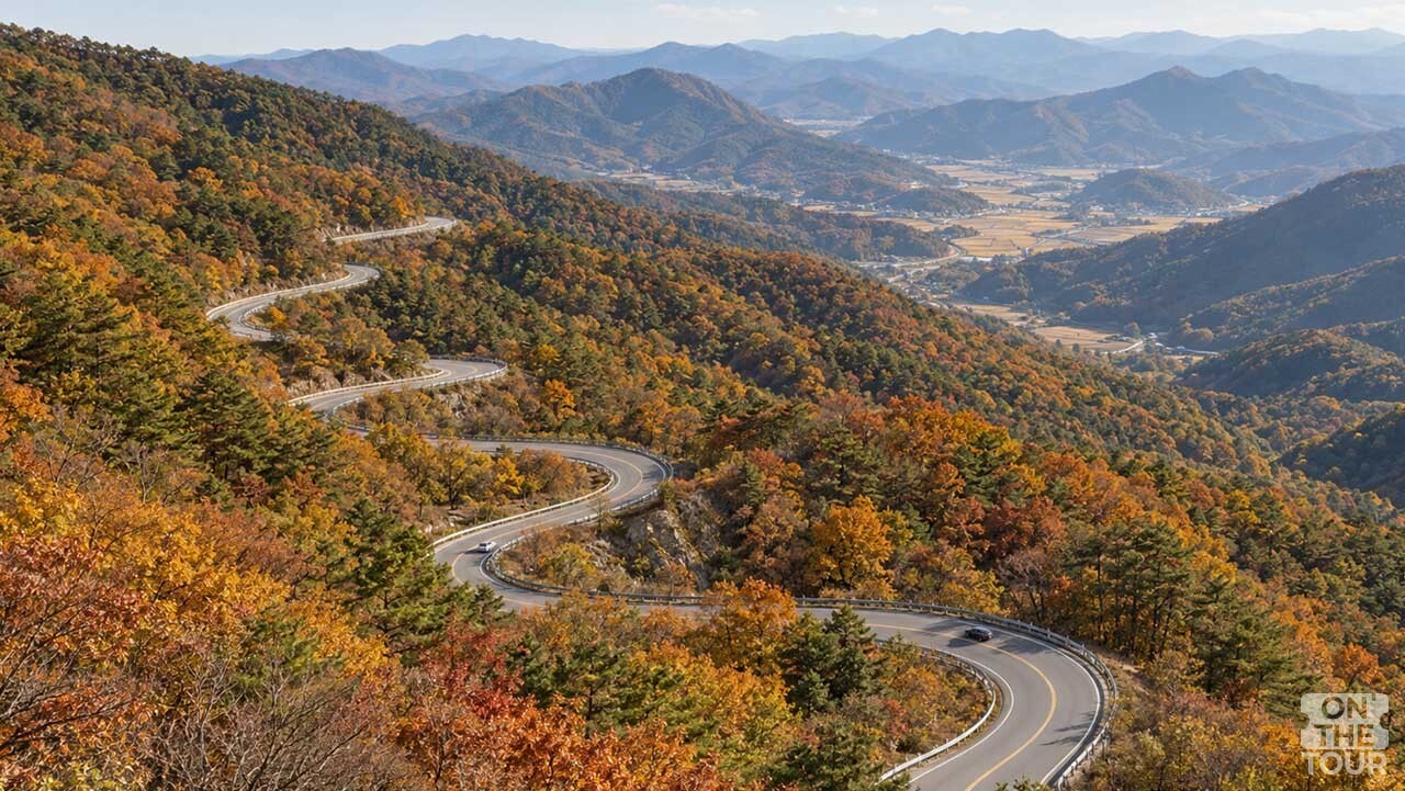 울긋불긋한 가을 숲 사이로 굽이진 도로가 이어지는 보은 말티재. (AI 생성) / 온더투어