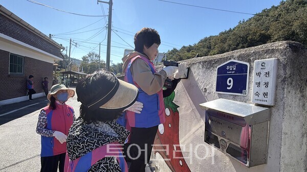 한국생활개선화순군연합회 회원들이 마을 골목에 ' 반딧불이 태양광 벽부등'을 설치하고 있다./사진=화순군