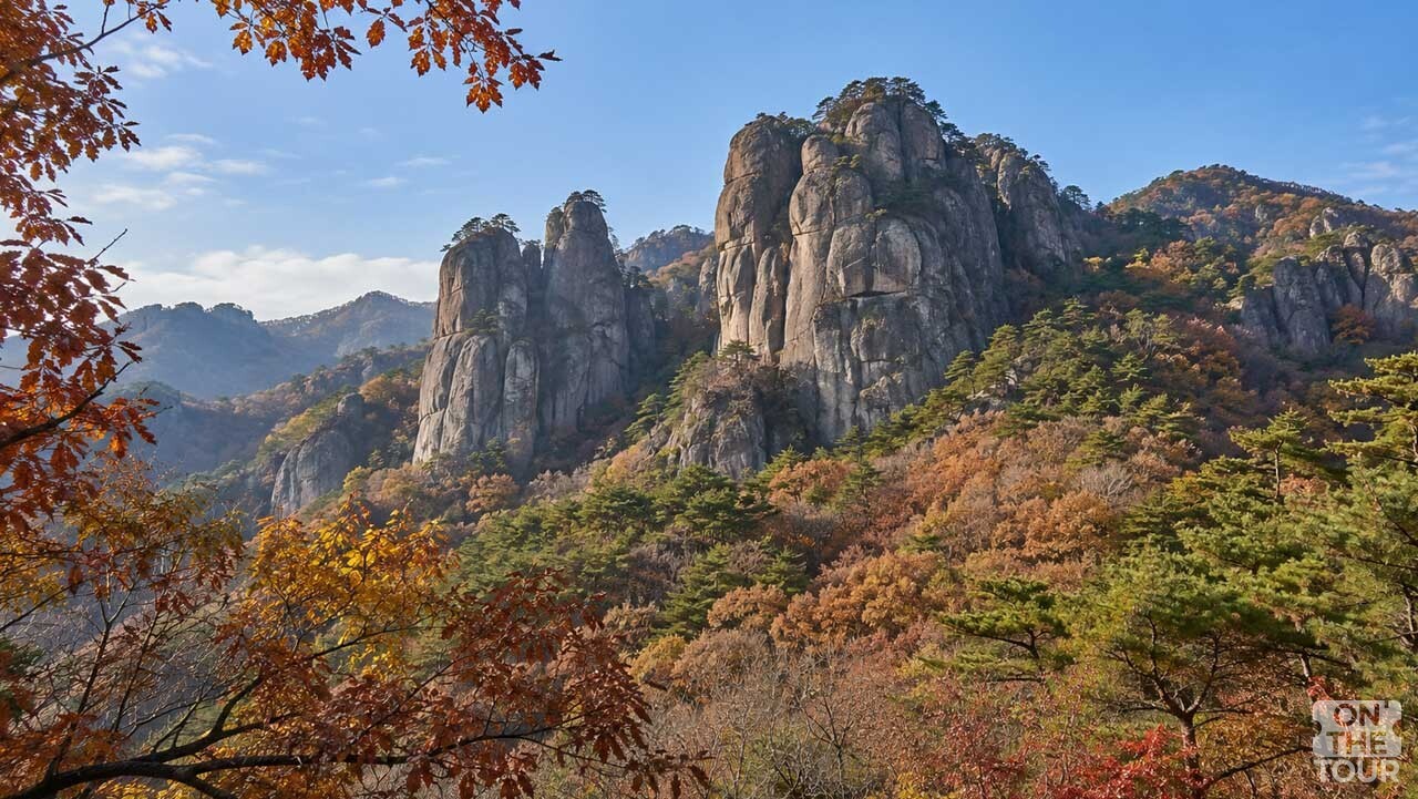 가을빛으로 물든 숲 위로 솟아오른 주왕산 기암괴석. (AI 생성) / 온더투어