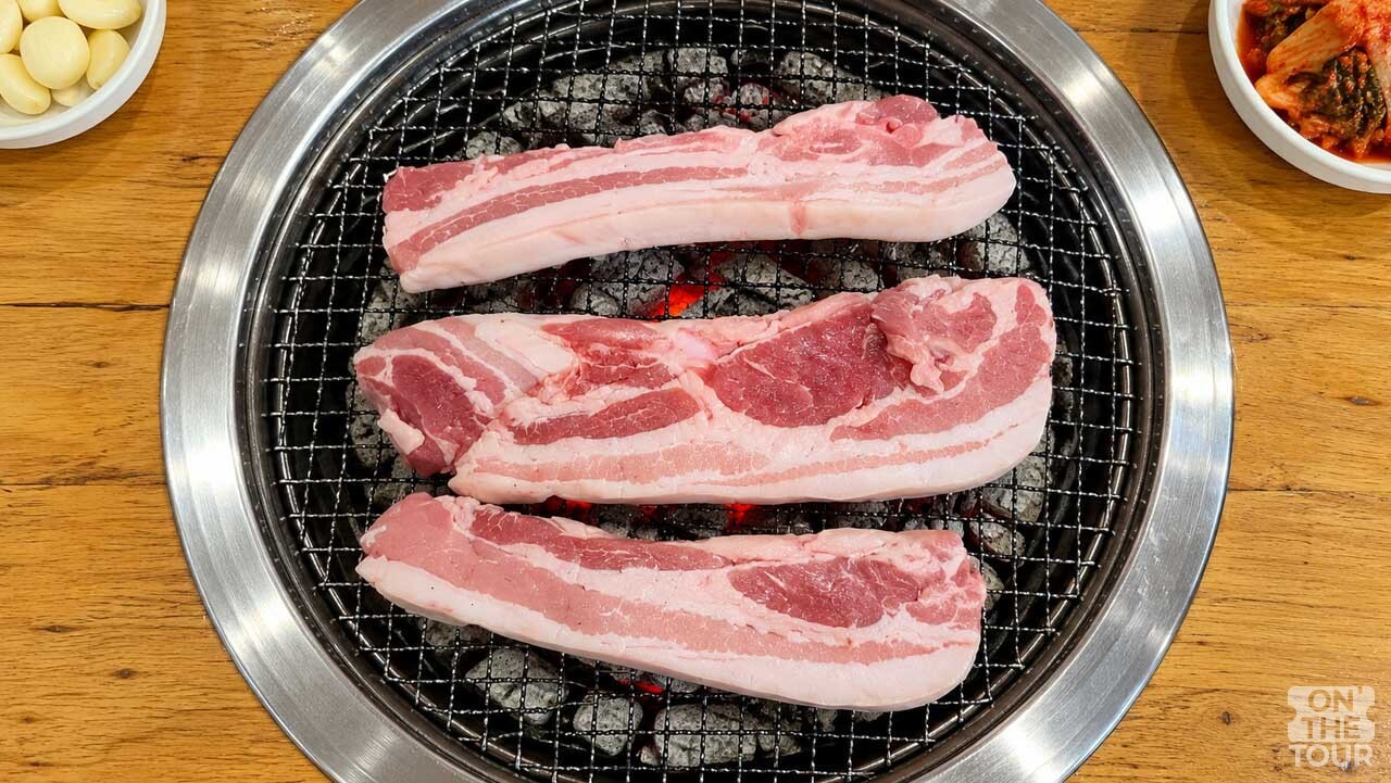 치악산 참숯가마에서 즐기는 숯불 삼겹살. (AI 생성) / 온더투어