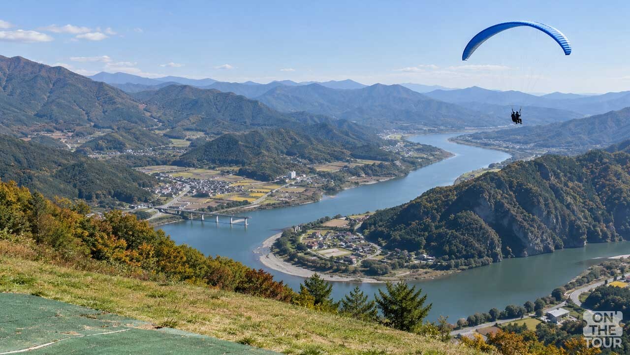 산 위 활공장에서 바라본 남한강과 겹겹이 이어진 단양의 산 능선. (AI 생성) / 온더투어