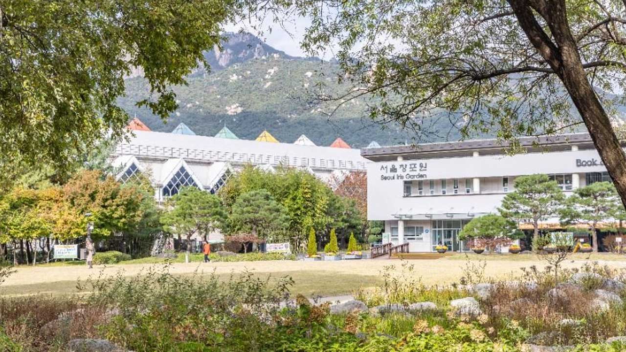 경남 거창 창포원 잔디밭 너머로 전시관 건물이 보이고, 뒤로 바위산이 솟아 있다. / 대한민국 구석구석