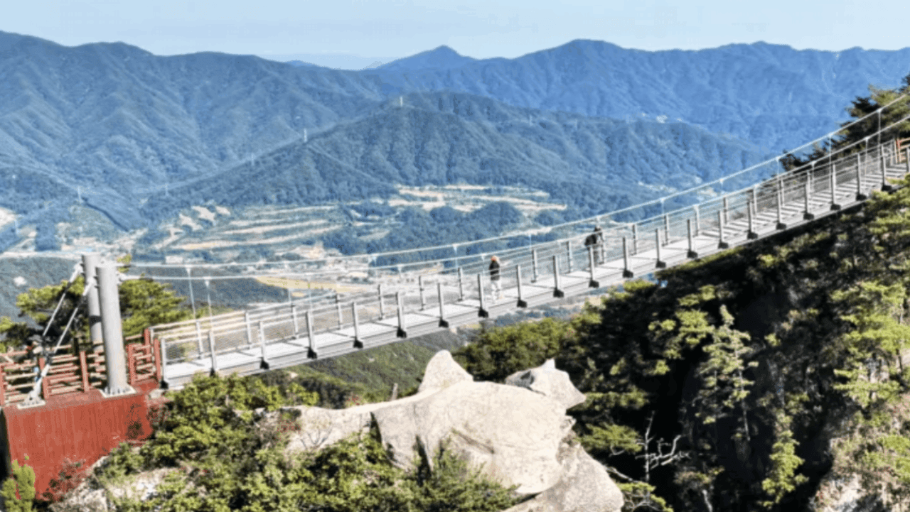 산줄기를 배경으로 암봉 사이에 걸린 출렁다리를 탐방객이 건너고 있다. / 포천시청 공식 SNS