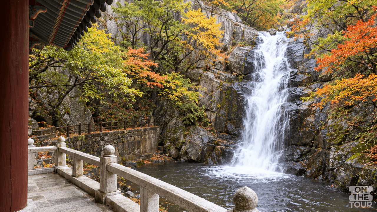 경남 양산 홍룡사 관음전 옆에서 바라본 홍룡폭포와 울긋불긋한 가을 숲. (AI 생성) / 온더투어