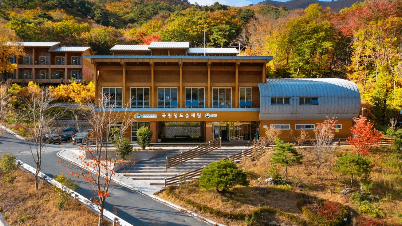 '국립청도숲체원' 간판을 단 본부 건물과 단풍이 든 뒷산. / 국립청도숲체원