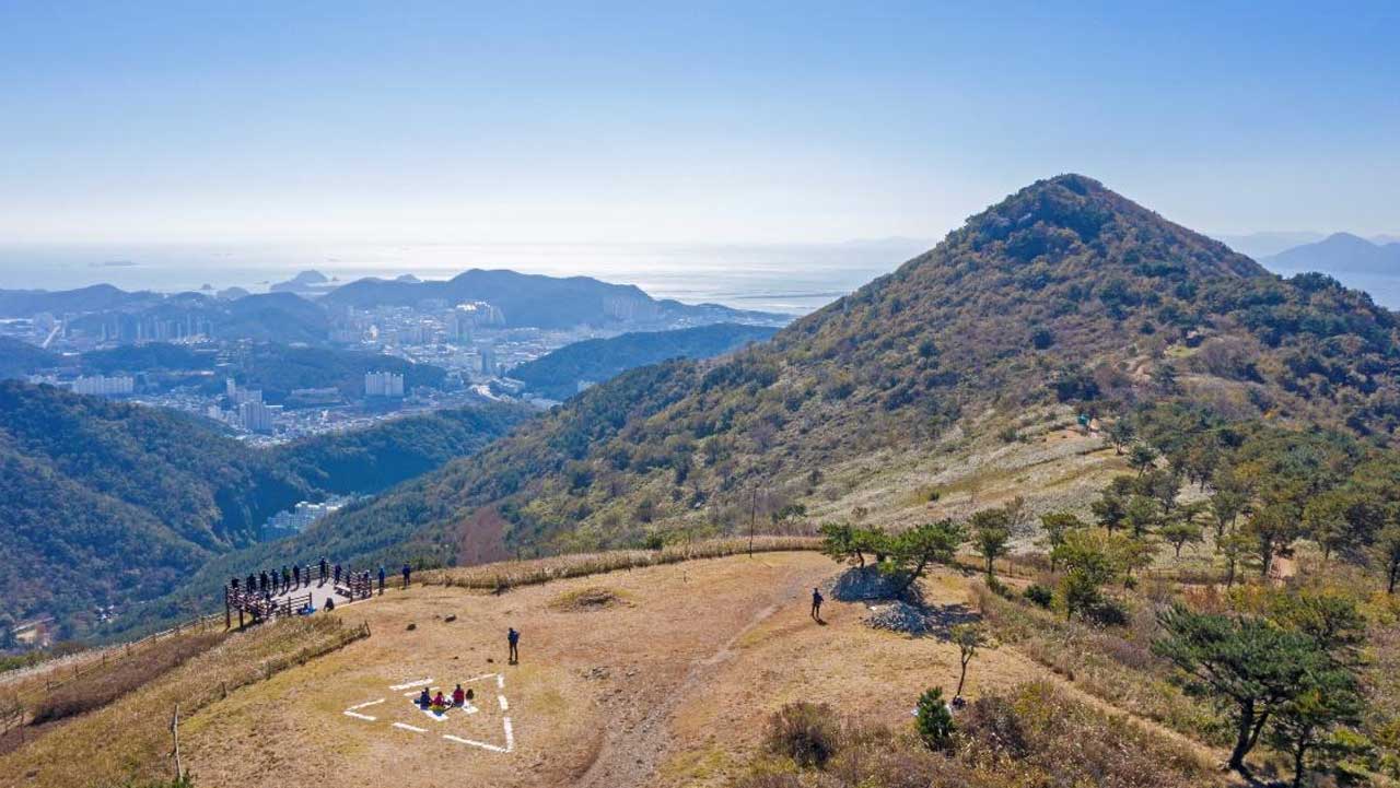 부산 승학산 능선 전망 데크에서 등산객들이 시내와 남해 쪽을 바라보고 있다. / 비짓부산