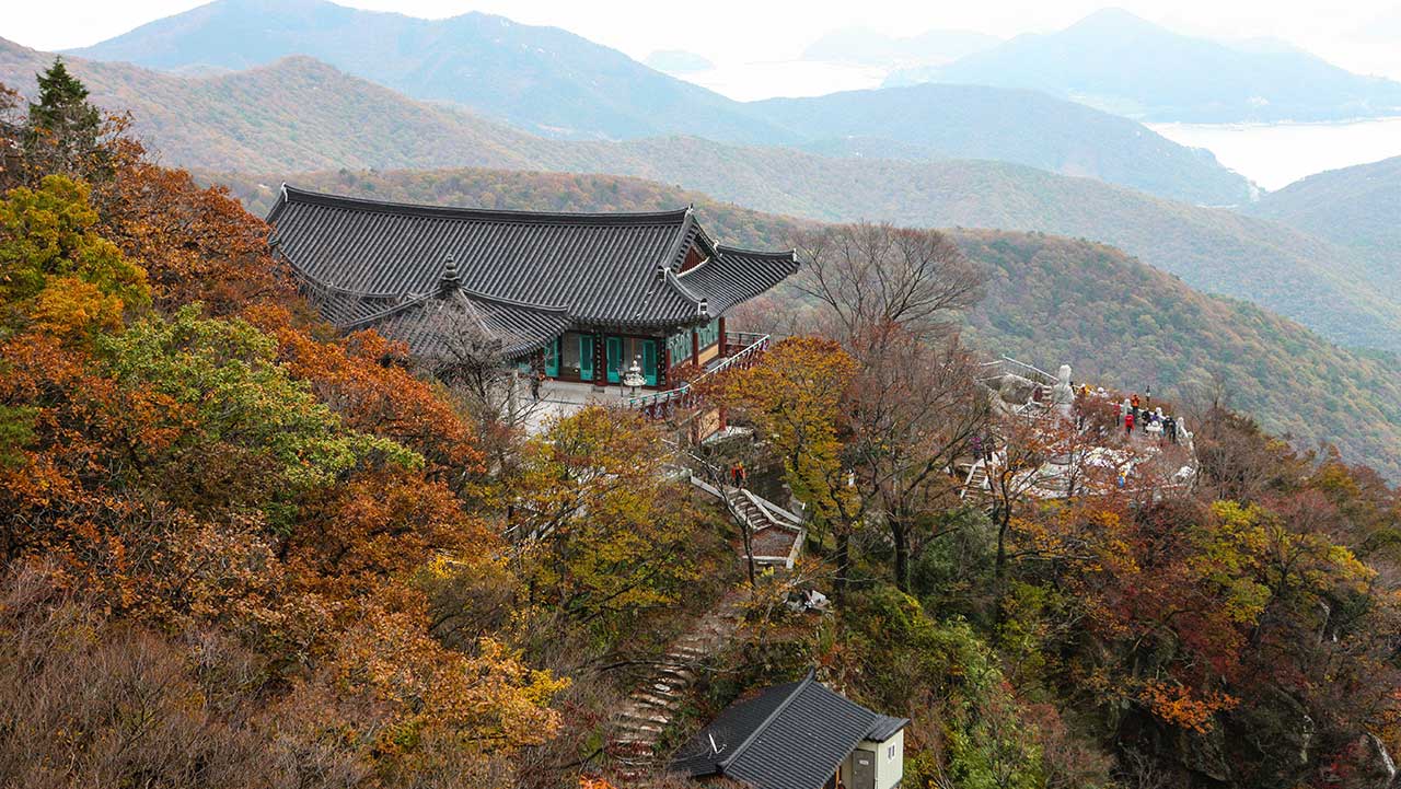 보리암 법당이 단풍 든 산비탈에 자리해 멀리 남해 바다를 내려다보고 있다. / ⓒ한국관광콘텐츠랩-김지호