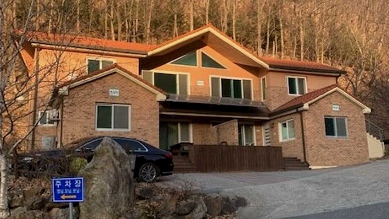 영동 민주지산자연휴양림 숙박시설 앞에 주차장 안내판과 차량이 놓인 모습. / 숲나들e