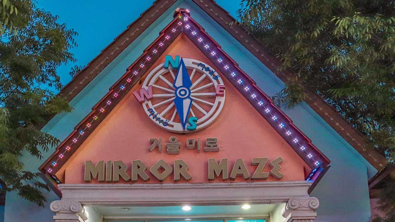 청도 프로방스 거울미로 입구에 나침반 모양 간판과 조명이 켜진 모습. / 경북 공식 SNS