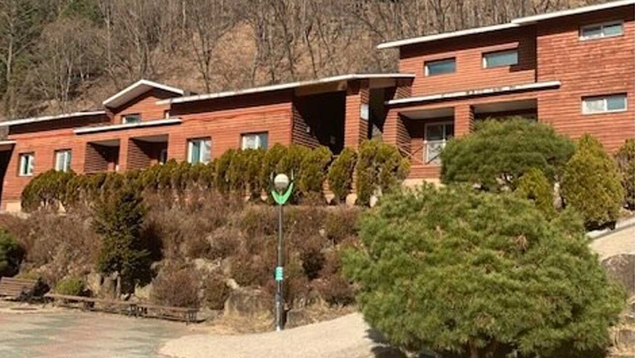 영동 민주지산자연휴양림 숲속의집으로 보이는 붉은 갈색 목조 숙박시설 외관. / 숲나들e