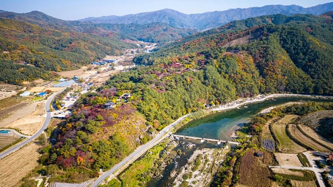 홍천 척야산 문화수목원 일대와 강줄기를 단풍 든 산자락과 함께 내려다본 모습. / 홍천군청, ai