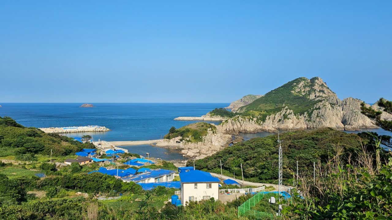 신안 만재도 언덕에서 내려다본 포구와 마을, 바다 건너 이어진 바위 능선. / 울산항만공사 공식 SNS