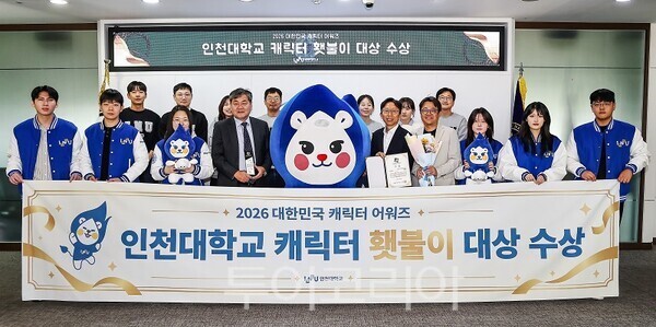2026 대한민국 캐릭터 어워즈 대상 수상을 기념해 인천대학교 주요 관계자와 학생들이 마스코트 ‘횃불이’와 함께 기념촬영을 하고 있다.