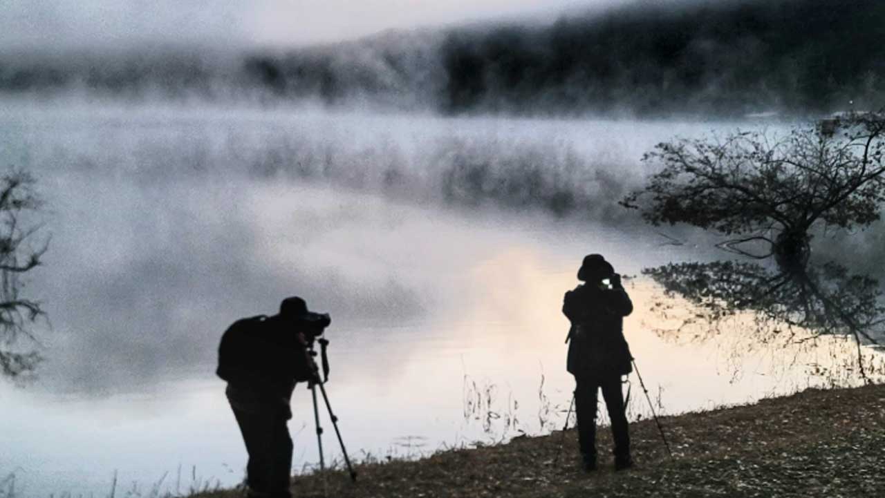 괴산 문광저수지에 물안개가 낀 이른 아침, 삼각대를 세운 사진가들이 수면을 촬영하고 있다. / 충북 공식 SNS