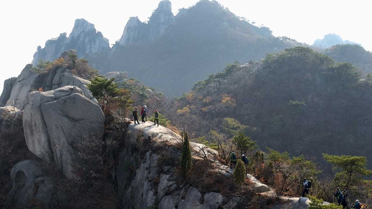 도봉산 암릉 위를 걷는 등산객 뒤로 암봉이 이어진다. / 의정부시 문화관광