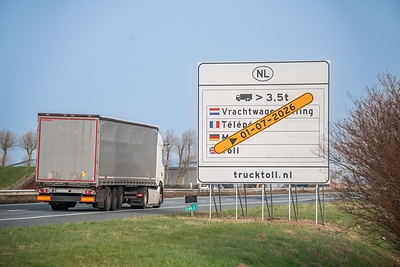 A truck passes a sign indicating the truck toll in the Netherlands. 